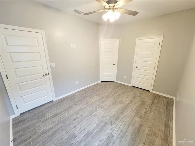 Unfurnished bedroom with light wood finished floors and ceiling fan | Image 15