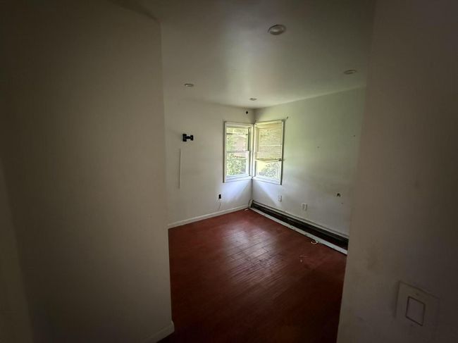 Unfurnished room with wood finished floors, baseboard heating, and recessed lighting | Image 8
