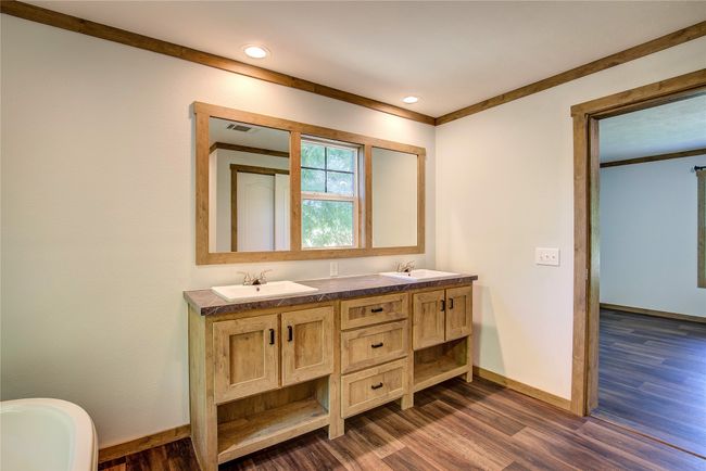 Bathroom with wood finished floors, double vanity, recessed lighting, and a freestanding tub | Image 13