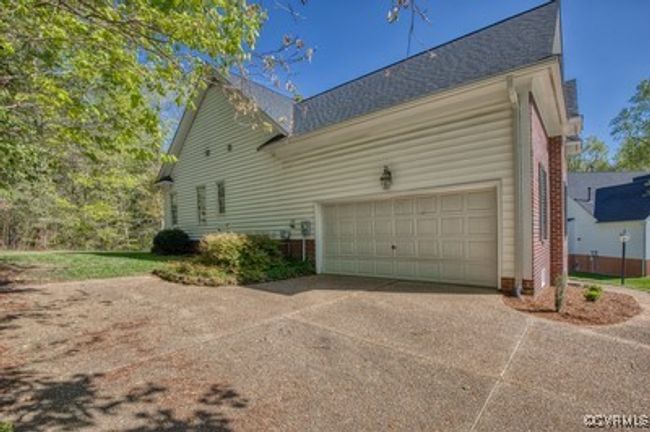 View of side of property featuring an attached garage and concrete driveway | Image 32