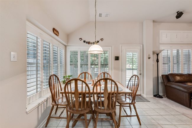 Dining space with light tile patterned floors, vaulted ceiling, and baseboards | Image 13