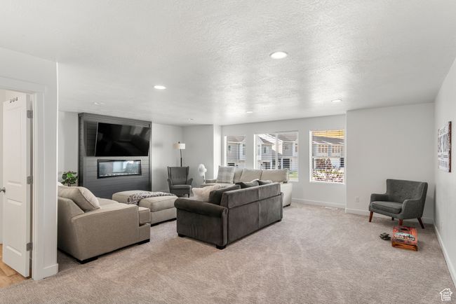 Living area with recessed lighting, light colored carpet, a textured ceiling, and baseboards | Image 17
