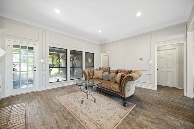 Living area featuring a decorative wall, ornamental molding, recessed lighting, and dark wood-style floors | Image 7