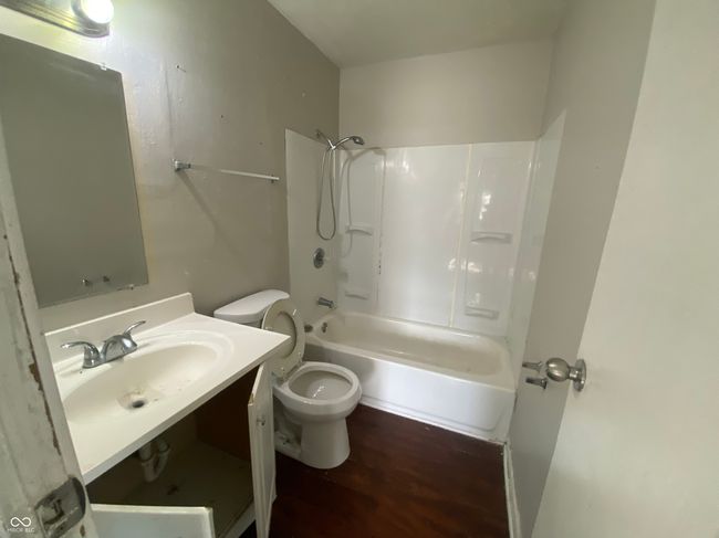 full bathroom with wood finished floors, toilet, shower / washtub combination, and vanity | Image 13