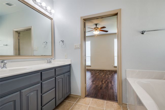 Bathroom featuring double vanity, ceiling fan, a garden tub, and tile patterned floors | Image 22