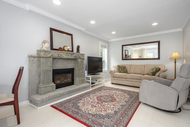 Living area with recessed lighting, a fireplace, and crown molding | Image 8