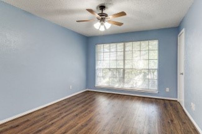 Spare room with plenty of natural light, a textured ceiling, ceiling fan, and wood finished floors | Image 9