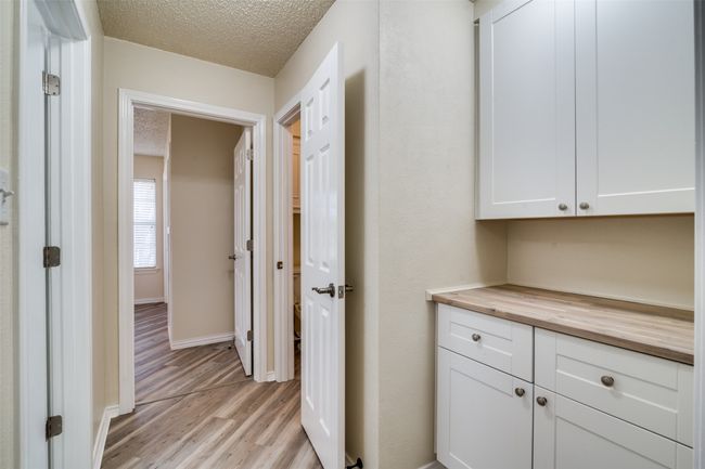 Hall with light wood-style floors, baseboards, and a textured ceiling | Image 10