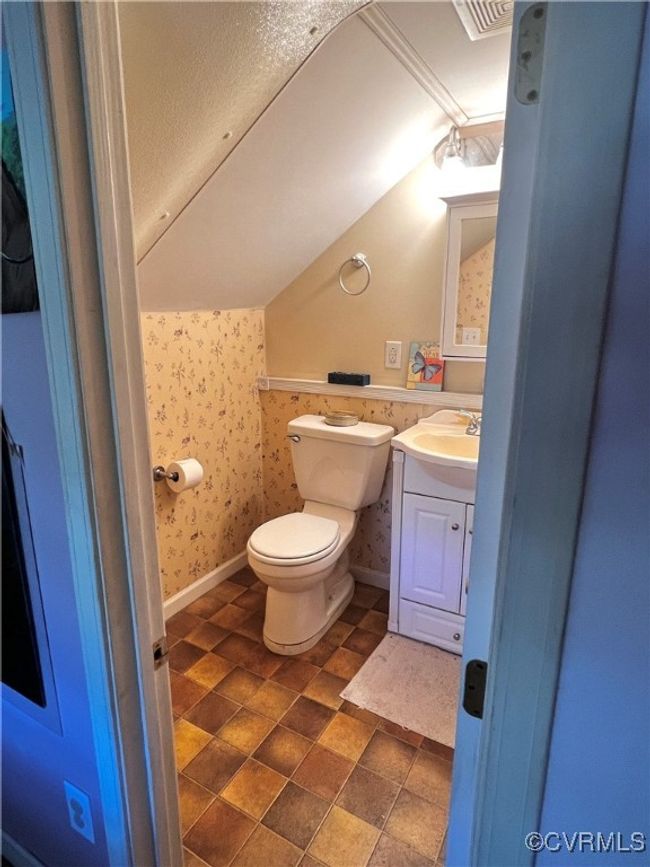 Bathroom featuring vaulted ceiling, toilet, and vanity | Image 33