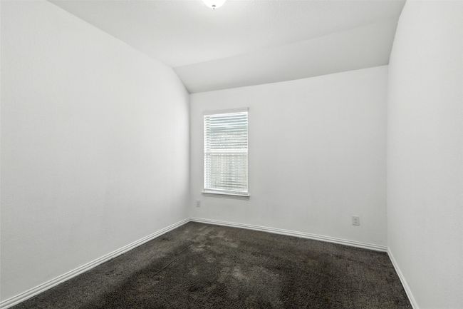 Spare room with dark colored carpet and lofted ceiling | Image 19