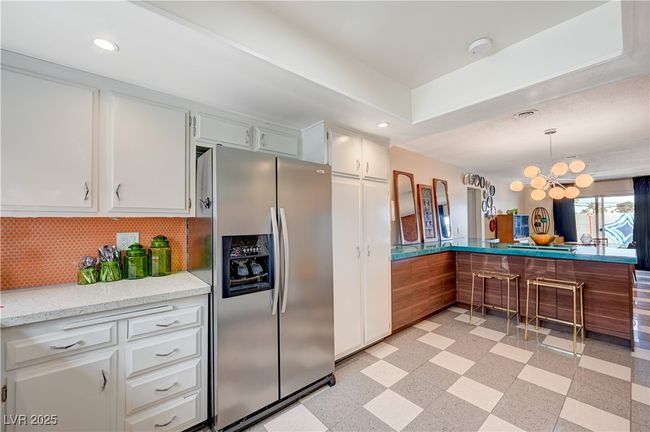 Kitchen featuring light floors, stainless steel fridge, a notable chandelier, and recessed lighting | Image 21
