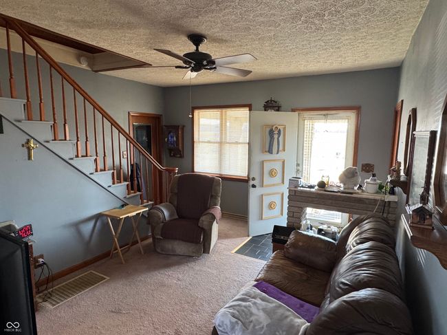 living room featuring stairs, ceiling fan, carpet flooring, and a textured ceiling | Image 23