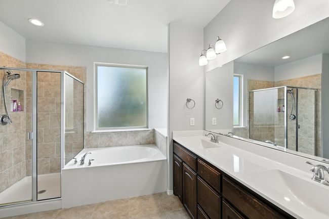 Bathroom featuring a bath, a shower stall, and double vanity | Image 11