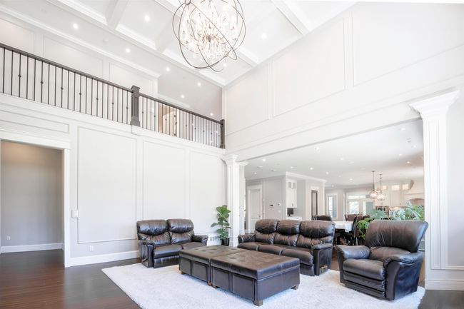 Living room featuring decorative columns, an inviting chandelier, and a decorative wall | Image 7