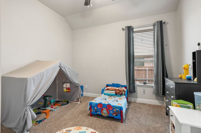 Carpeted bedroom featuring vaulted ceiling and a ceiling fan | Image 12