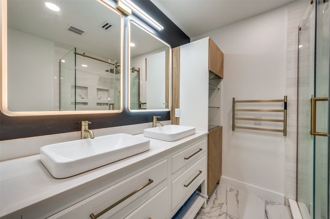 Bathroom with double vanity, a shower stall, marble look tiles, and recessed lighting | Image 18