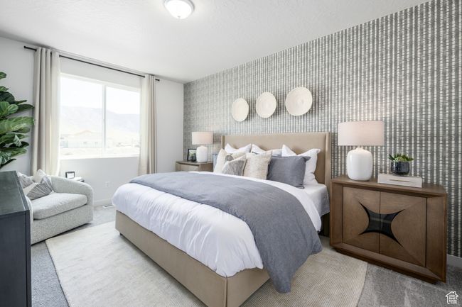 Bedroom with carpet floors, wallpapered walls, an accent wall, and baseboards | Image 11