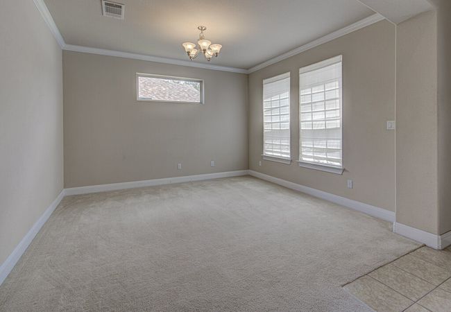 Unfurnished room featuring crown molding, a chandelier, and light colored carpet | Image 4