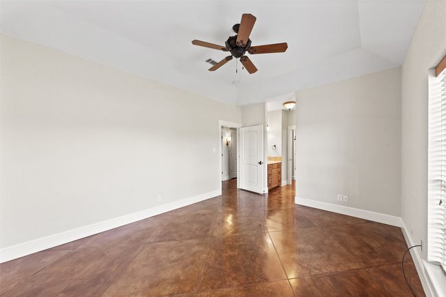 Unfurnished bedroom with baseboards, dark tile patterned floors, and a ceiling fan | Image 26
