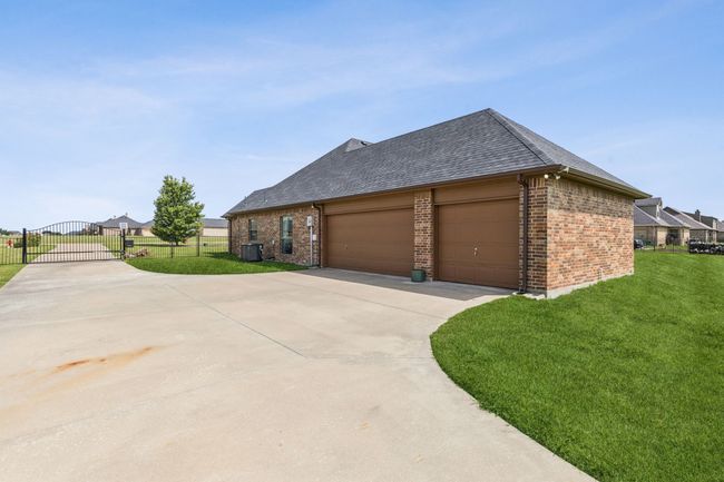View of side of property featuring driveway and the 3 car garage. | Image 33