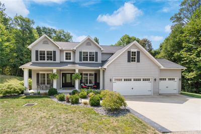 View of front of property featuring 3 car garage, a front lawn, and a porch | Image 1