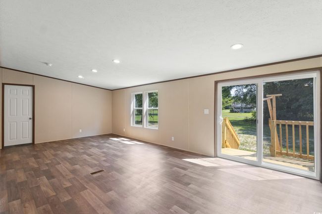 Unfurnished room featuring wood finished floors, healthy amount of natural light, recessed lighting, and ornamental molding | Image 16