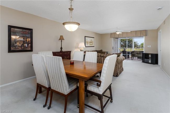 Dining space with ceiling fan, baseboards, visible vents, and light colored carpet | Image 6