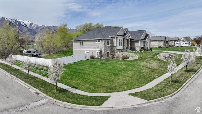 View of side of property with a yard, a residential view, stone siding, and fence | Image 17