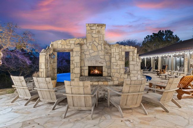 Patio terrace at dusk featuring an outdoor stone fireplace | Image 19