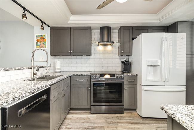 BEAUTIFULLY UPDATED KITCHEN. CABINETS. GRANITE COUNTERTOPS. UNDER-MOUNT STAINLESSFULL-HEIGHT SUBWAY TILE BACKSPLASH. MODERN HOOD W/LIGHTING. | Image 9