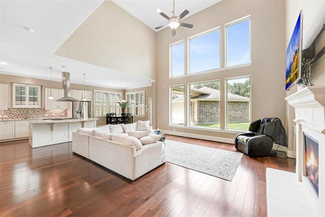 Expansive living room with soaring ceilings 22', a wall of windows for abundant natural light, and a cozy fireplace. | Image 8
