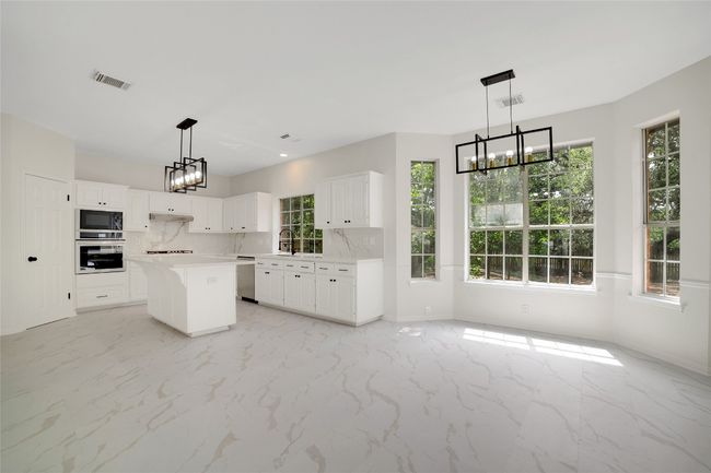 Kitchen with appliances with stainless steel finishes, a chandelier, plenty of natural light, and light countertops | Image 9