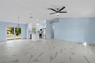 Unfurnished living room with lofted ceiling, light tile patterned flooring, and ceiling fan | Image 3