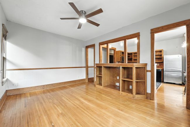 Open-concept layout showcasing built-ins, original wood trim, and direct kitchen access for easy entertaining. | Image 10