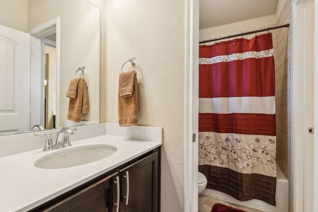 Full bathroom with toilet, vanity, and shower / bathtub combination with curtain | Image 22