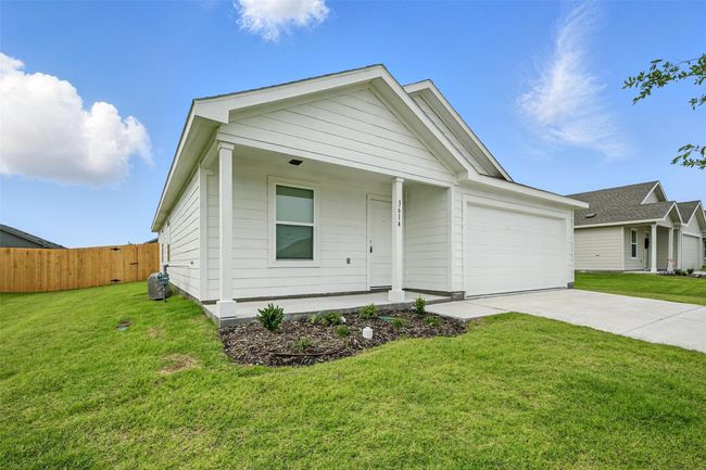 Ranch-style home with a garage, concrete driveway, and a porch | Image 21