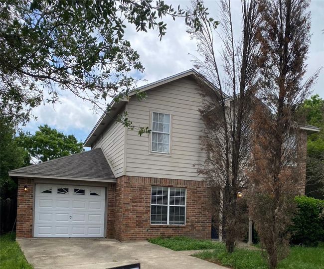 View of side of home with concrete driveway, brick siding, an attached garage, and a shingled roof | Image 25