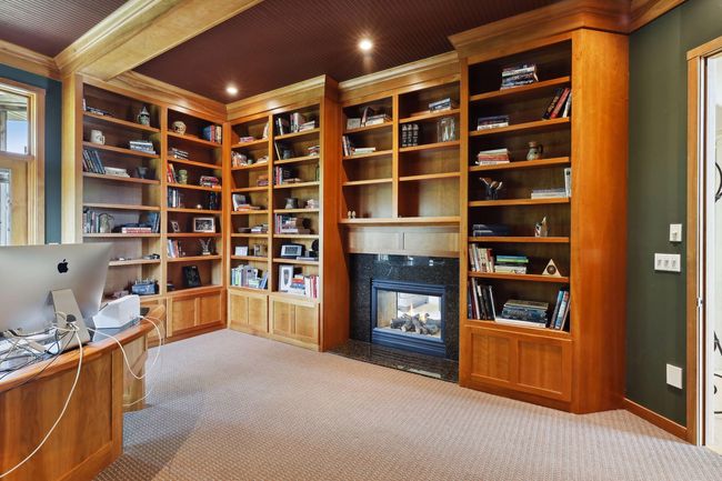 Custom office built-ins with an abundance of storage and shelving space for books, decor, pictures and more! Double sided fireplace for those chilly nights and work days! What a perfect setup to work or run your business from home! | Image 19
