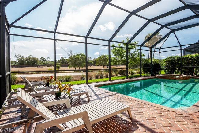 View of swimming pool with a patio, a pool with connected hot tub, and a lanai | Image 26