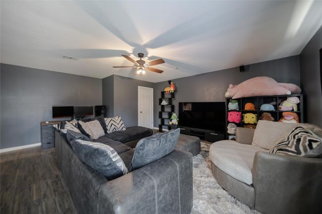 Living area with a ceiling fan and wood finished floors | Image 14