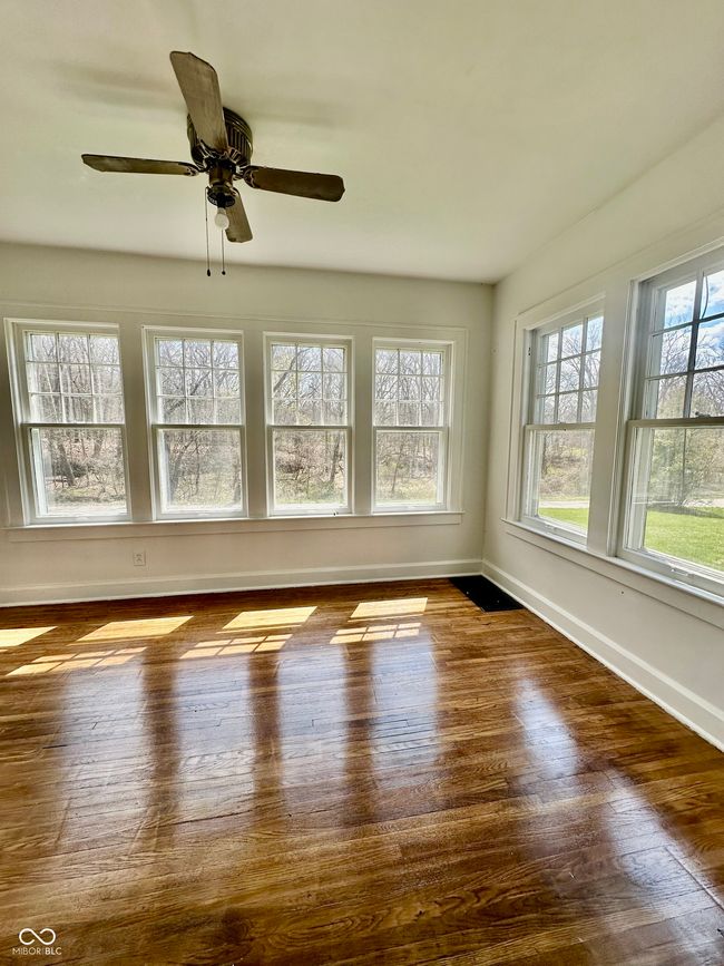 empty room with baseboards, a ceiling fan, and wood finished floors | Image 25