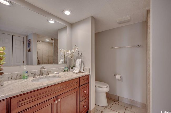 Bathroom featuring vanity, walk in shower, a textured ceiling, tile patterned flooring, and toilet | Image 14