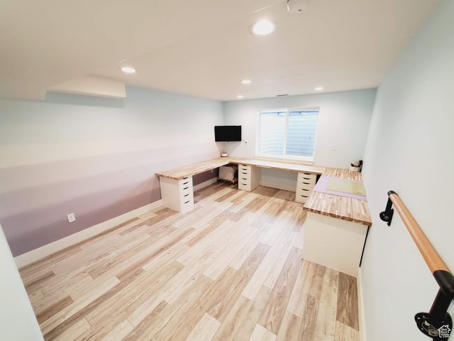 Unfurnished office with light wood-type flooring, baseboards, built in desk, and recessed lighting | Image 28