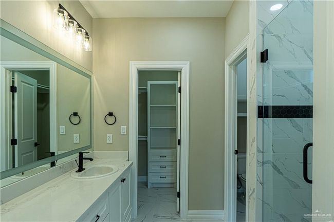Full bath featuring toilet, marble finish floor, a spacious closet, and vanity | Image 20