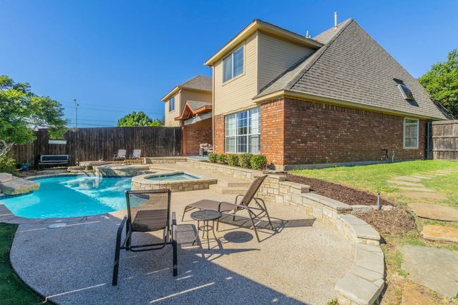 View of swimming pool with a fenced backyard, a patio, and a pool with connected hot tub | Image 37