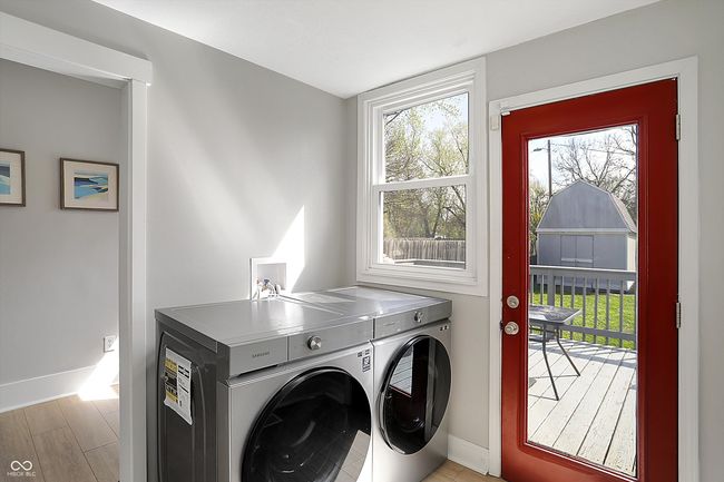 washroom with baseboards, washer and dryer, laundry area, and a healthy amount of sunlight | Image 23