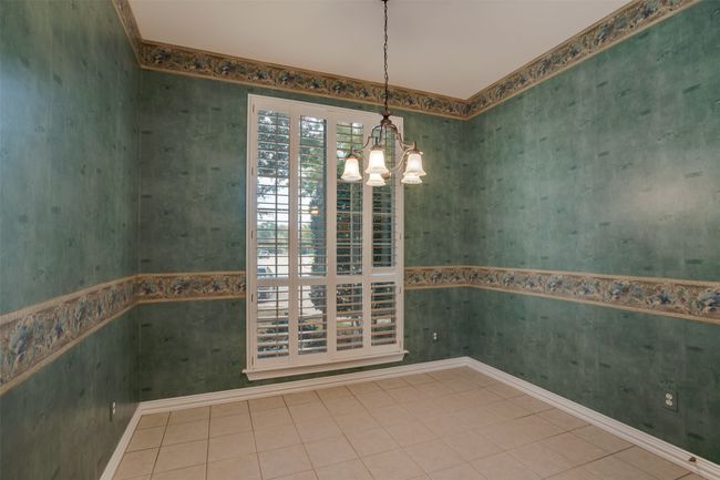 Empty room with a chandelier and wallpapered walls | Image 14