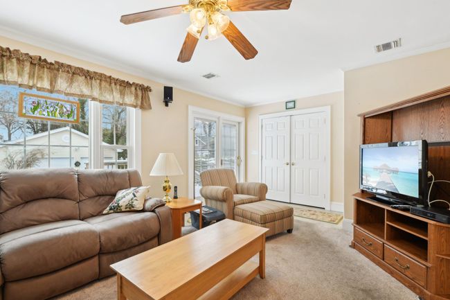 Carpeted living room with crown molding and ceiling fan | Image 14