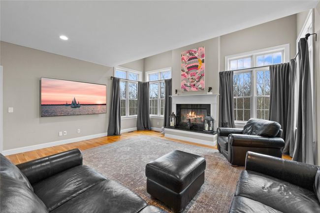 Living room with wood finished floors, baseboards, a glass covered fireplace, and recessed lighting | Image 9
