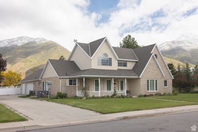 View of front of property featuring a mountain view, covered porch, a garage, and a front yard | Image 3